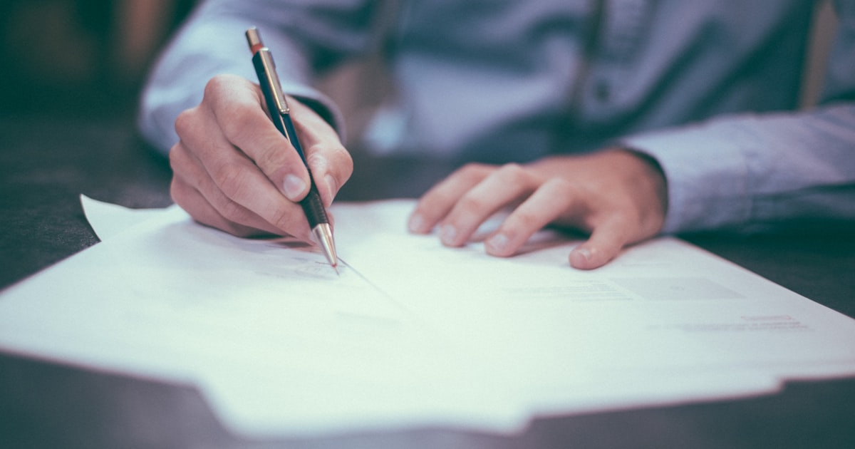 Person signing life insurance application on laptop representing no-exam process